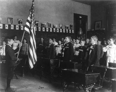 Students reciting the Pledge of Allegiance while saluting the U.S. flag (1899).